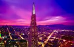 A vibrant view of San Francisco's skyline featuring the illuminated Transamerica Pyramid at sunset.