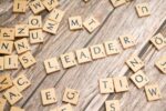 scrabble tiles spelling out the word leader in a word
