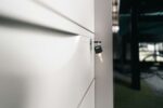 A close up of a door handle on a white door