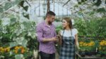 Couple shopping for plants in a greenhouse.