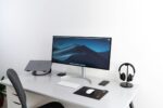 black flat widescreen computer monitor with with Apple Magic Keyboard and mouse on desk