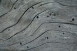 a close up of a wooden surface with holes in it