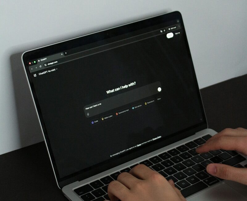 A person typing on a laptop on a table