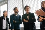 Group of diverse colleagues with headsets enjoying a conversation in a bright office setting.